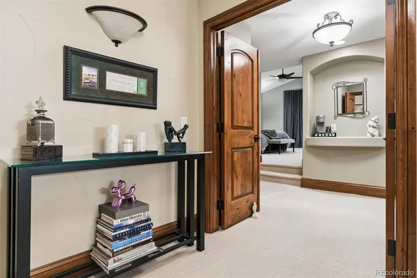 a view of hall way with furniture and paintings on the wall