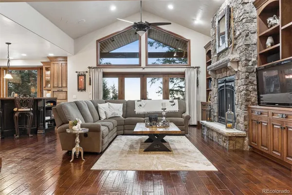 a living room with furniture large window and wooden floor