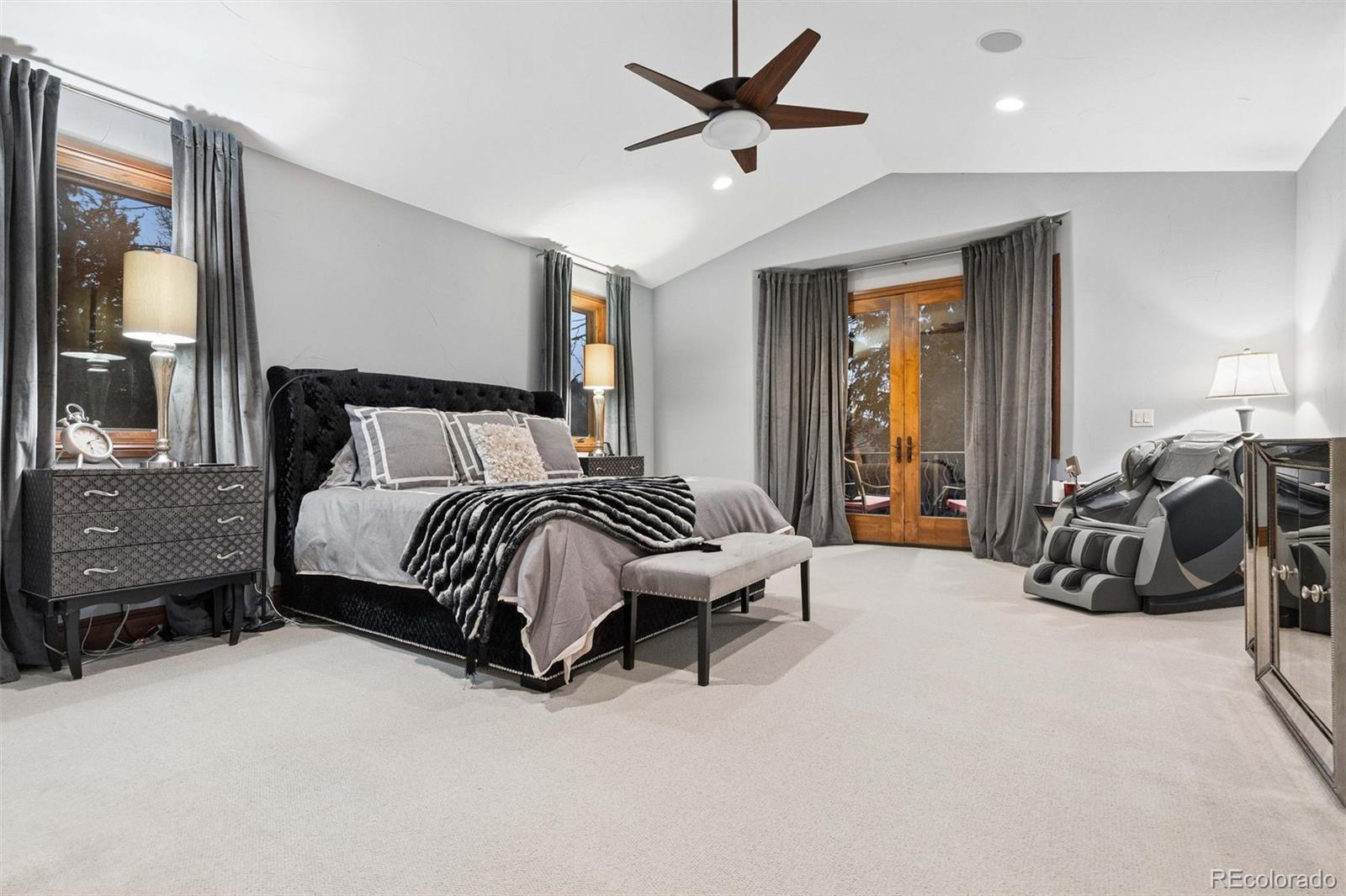 45 West Ranch Trail Morrison, CO 80465 - Photo 32 of 50 a spacious bedroom with a bed and a chandelier