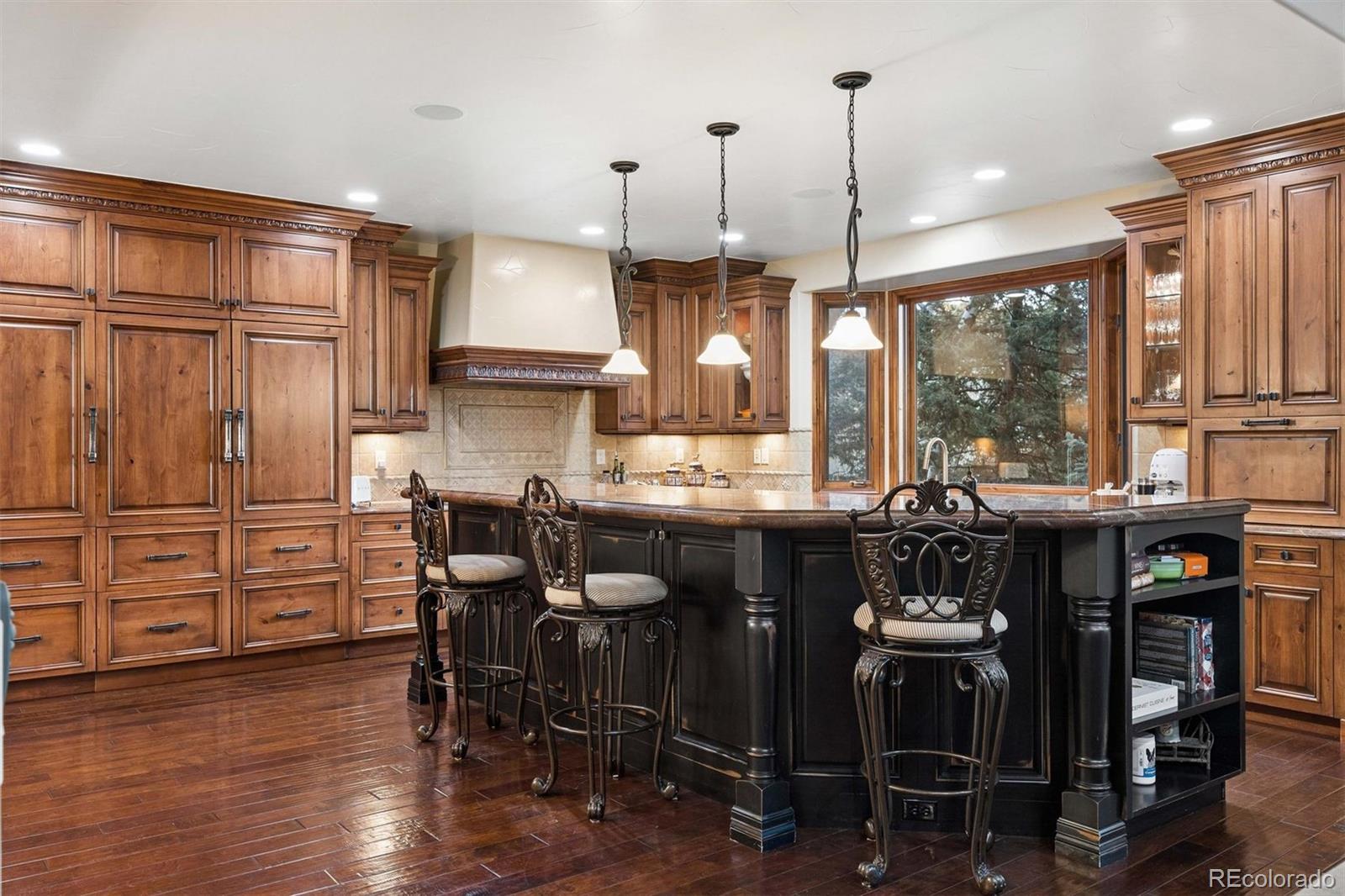 45 West Ranch Trail Morrison, CO 80465 - Photo 10 of 50 a kitchen with stainless steel appliances granite countertop a stove a refrigerator a sink a dining table and chairs with wooden floor