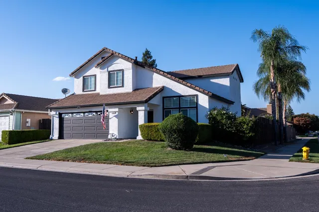 a front view of a house with a garden and plants