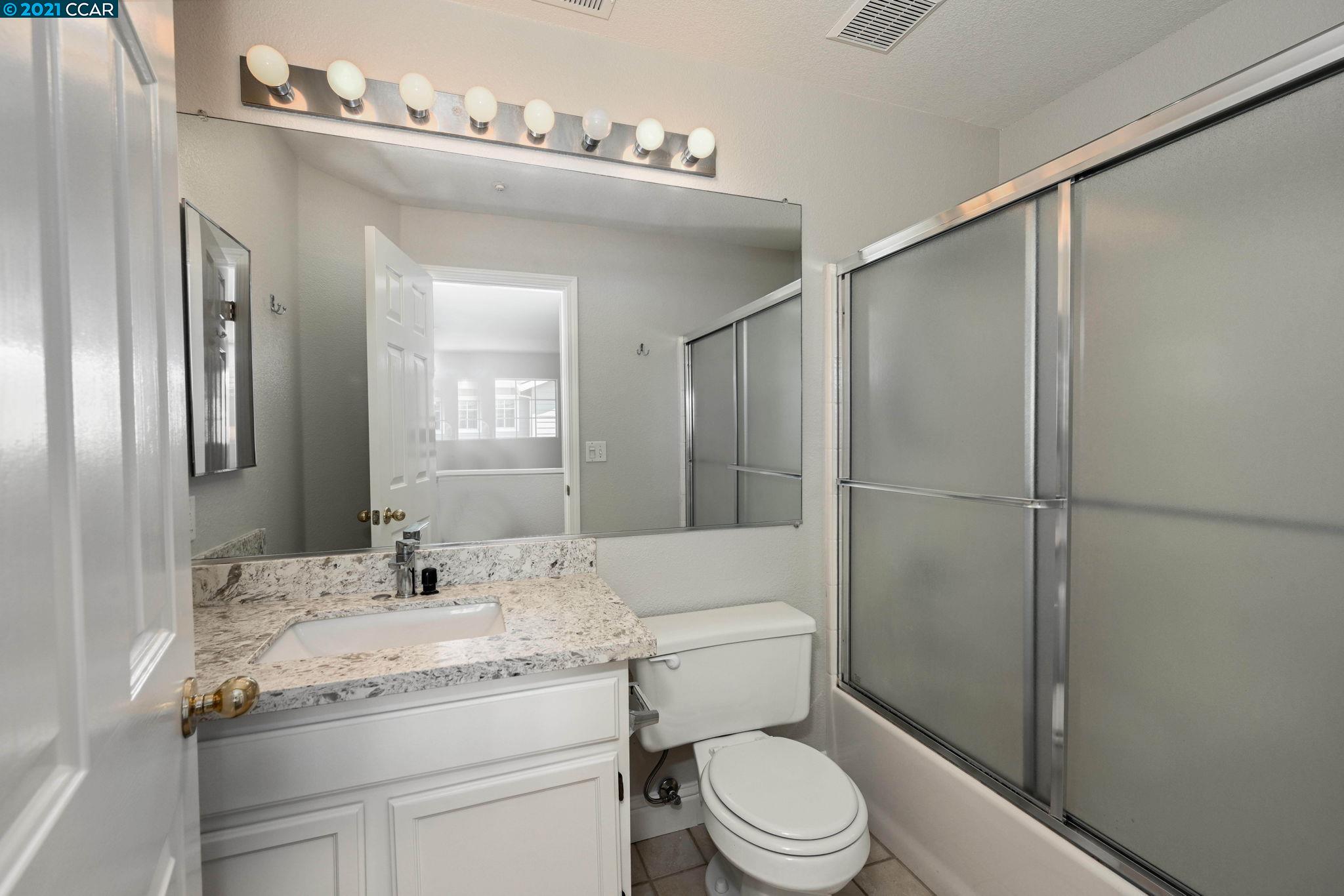 703 Destiny Lane San Ramon, CA 94583 - Photo 11 of 22 a bathroom with a granite countertop sink toilet a mirror and shower