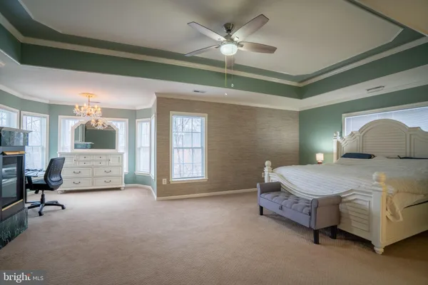 a spacious bedroom with a bed and a chandelier
