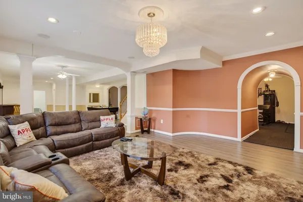 a dining hall with stainless steel appliances granite countertop a couch and wooden floor