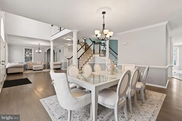 a view of a dining room and livingroom with furniture wooden floor a chandelier