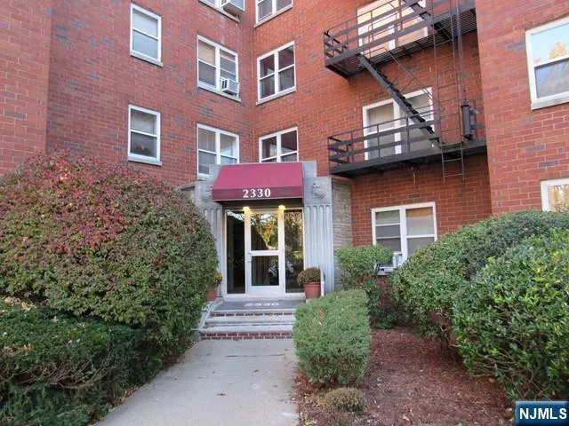 a view of a brick building with plants and large windows