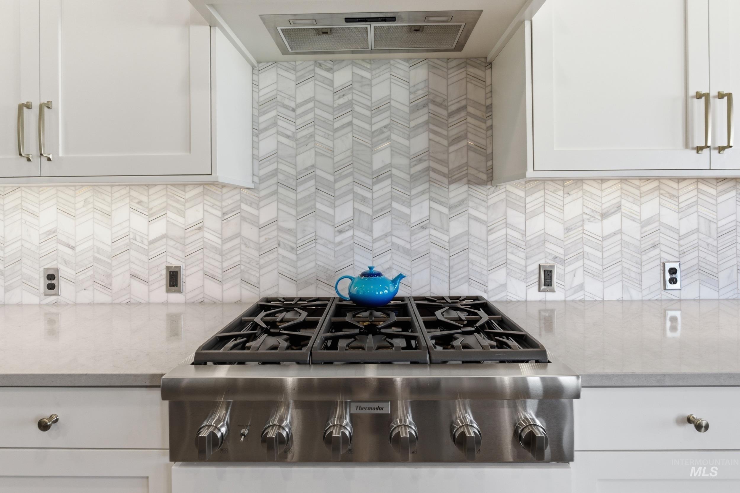 6347 South Utmost Lane Meridian, ID 83642 - Photo 10 of 37 Stainless steel gas range with a herringbone tile backsplash