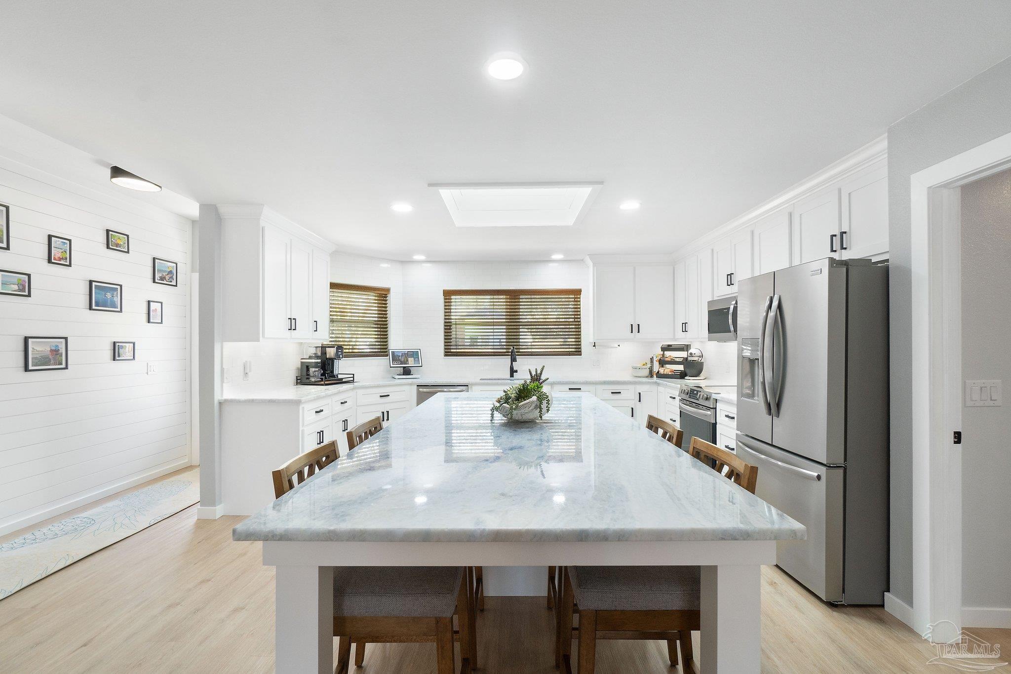 2016 Winners Circle Cantonment, FL 32533 - Photo 7 of 32 a kitchen with stainless steel appliances granite countertop a dining table chairs and refrigerator