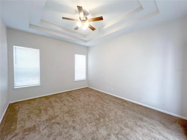 an empty room with a window and a ceiling fan