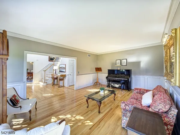 a living room with furniture a piano and a flat screen tv