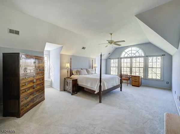 a spacious bedroom with a bed a couch and a walk in closet