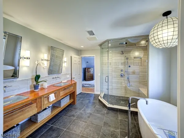 a bathroom with a double vanity sink a toilet a mirror and shower