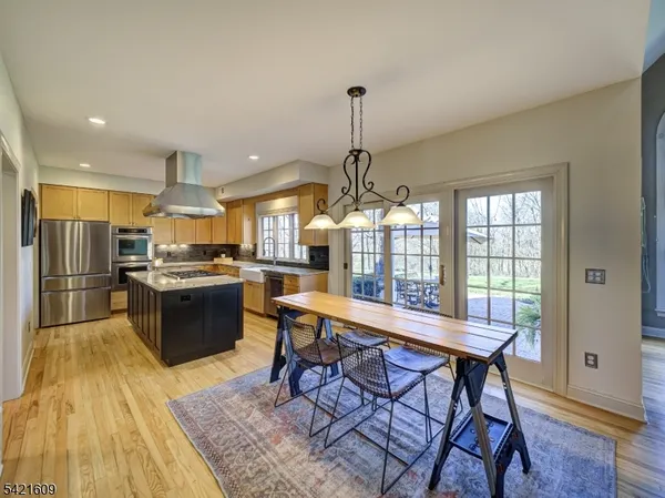 a kitchen with stainless steel appliances kitchen island granite countertop a sink table and chairs