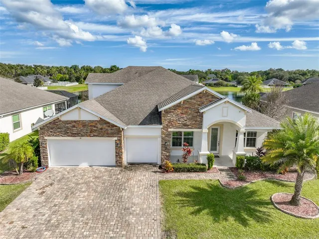 a front view of a house with a yard and mountain view in back