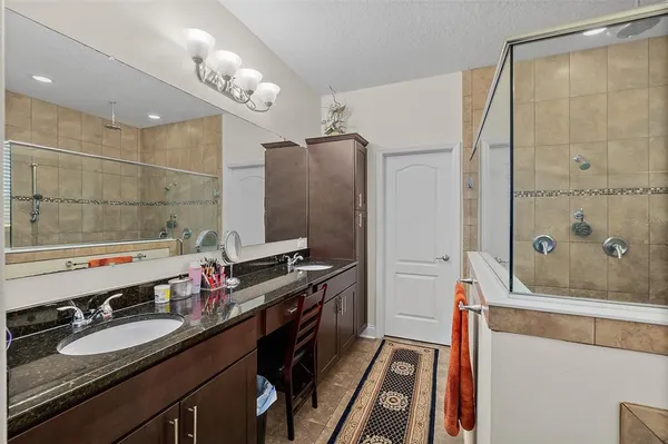a bathroom with a granite countertop sink toilet and shower