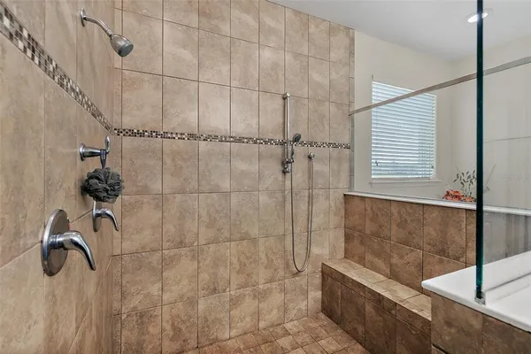 a bathroom with a granite countertop sink a toilet a mirror a bathtub and shower