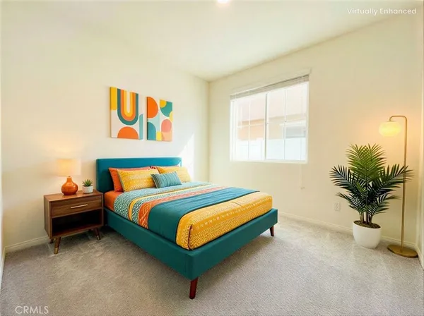 a bed sitting in a bedroom next to a window with potted plant