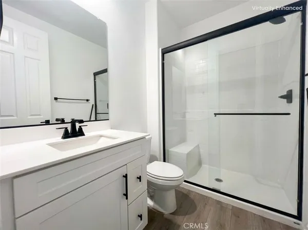 a bathroom with a shower sink vanity mirror and toilet