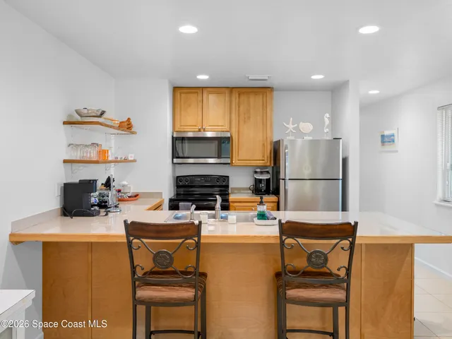 a living room with furniture a flat screen tv and kitchen view