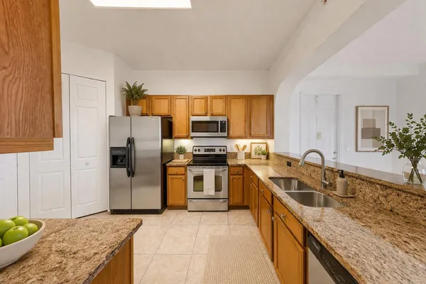 a kitchen with granite countertop a sink and stainless steel appliances