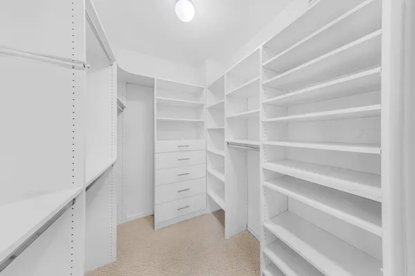 a view of walk in closet with empty racks