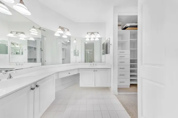 a large bathroom with a double vanity sink a mirror and a shower