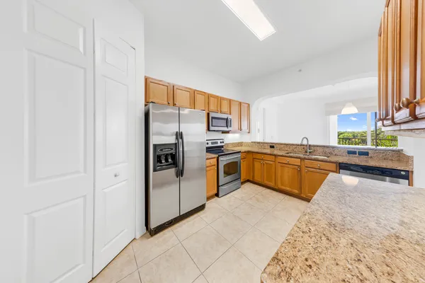 a kitchen with stainless steel appliances granite countertop a stove a sink and a refrigerator