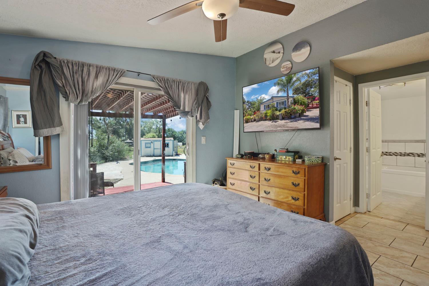 901 Quail Oaks Road Valley Springs, CA 95252 - Photo 15 of 59 a bedroom with a bed and a flat screen tv