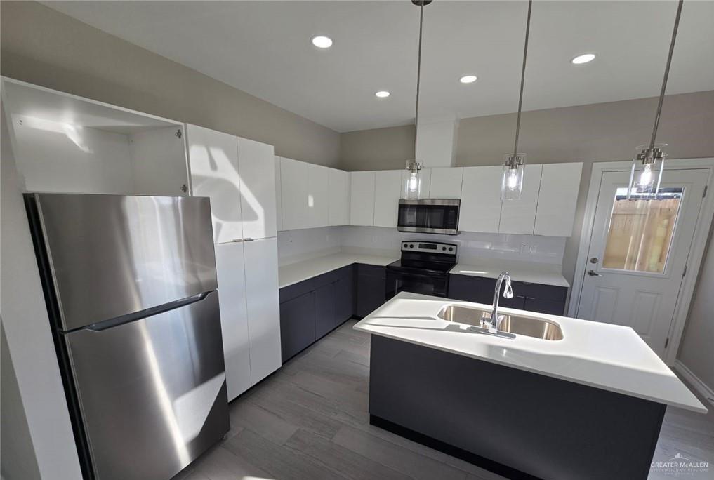 1420 South Xanthia Street, Unit 3 Alton, TX 78573 - Photo 7 of 12 a kitchen with refrigerator cabinets and wooden floor