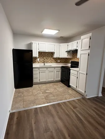 a kitchen with a sink a stove top oven and refrigerator