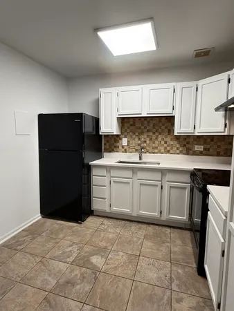 a kitchen with a refrigerator and a stove top oven