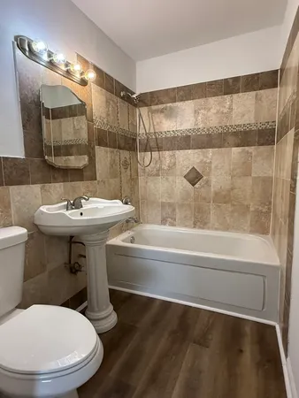 a bathroom with a sink a toilet and shower