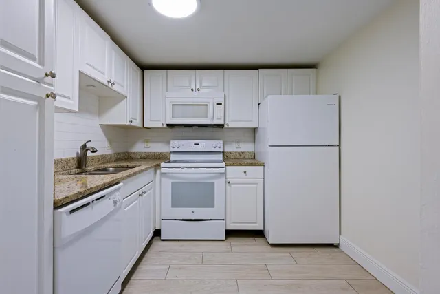 a kitchen with a refrigerator sink stove and cabinets