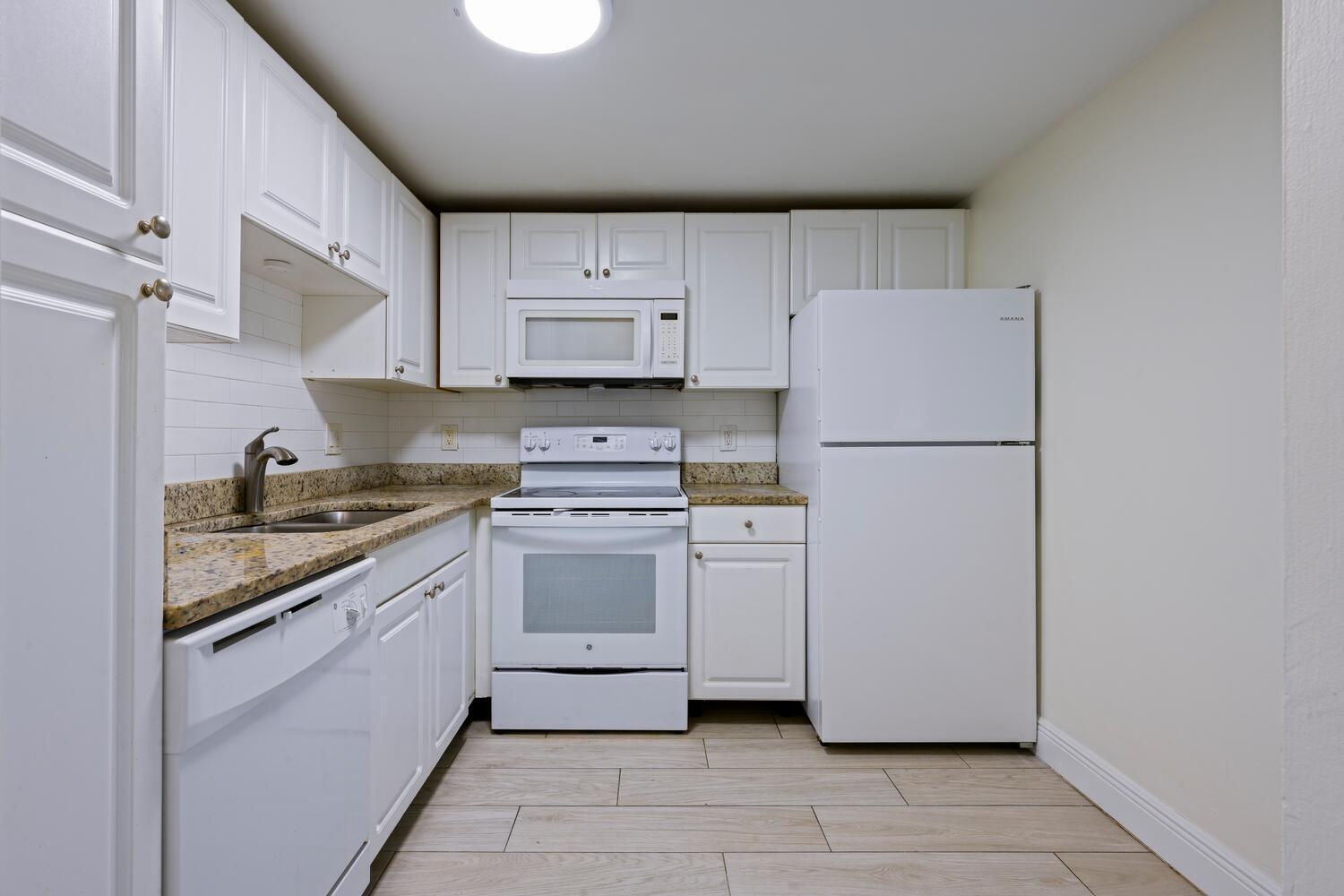 1505 Crescent Circle, Unit A8 Lake Park, FL 33403 - Photo 1 of 32 a kitchen with a refrigerator sink stove and cabinets