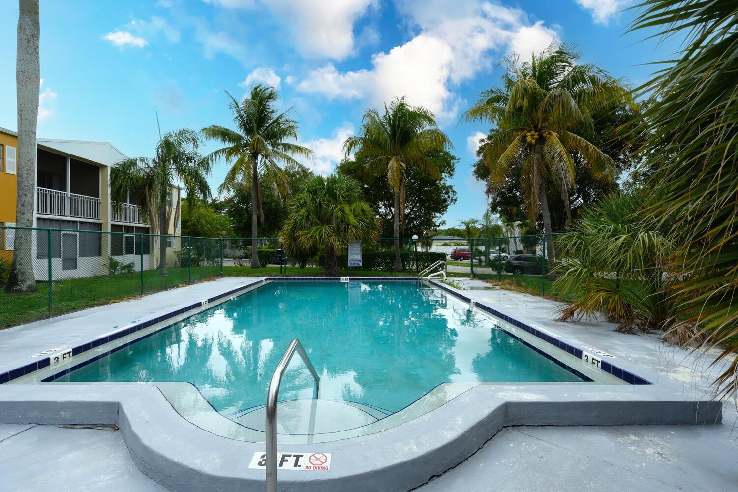 1505 Crescent Circle, Unit A8 Lake Park, FL 33403 - Photo 13 of 32 a view of swimming pool with a patio and palm trees