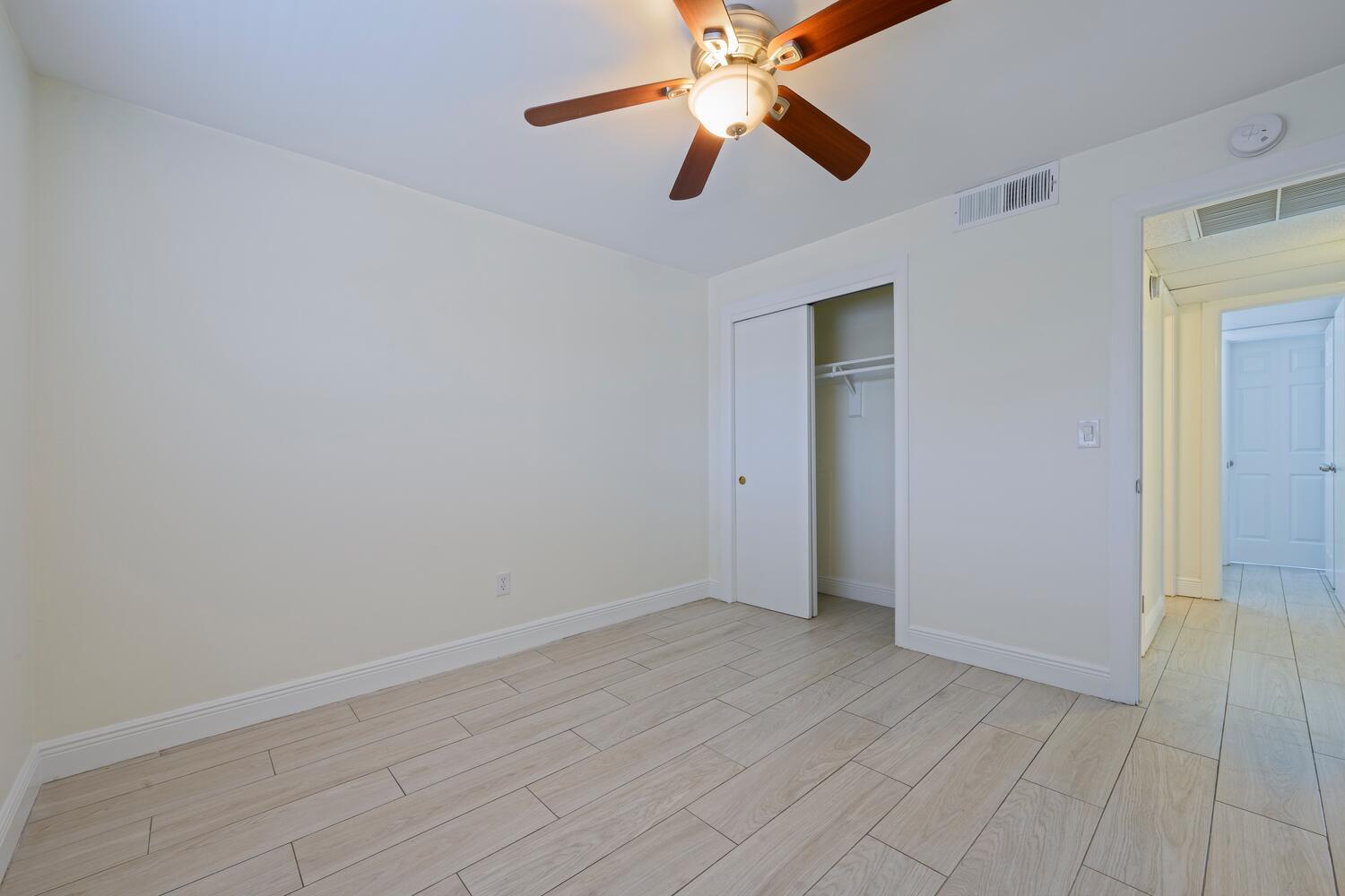 1505 Crescent Circle, Unit A8 Lake Park, FL 33403 - Photo 9 of 32 an empty room with closet and a ceiling fan