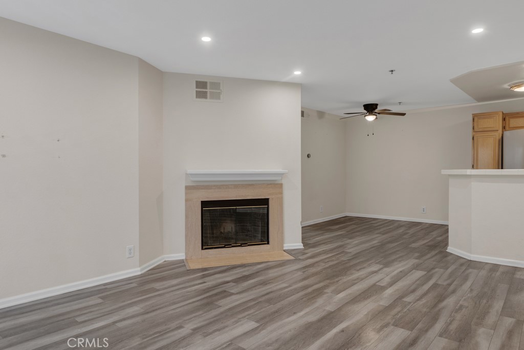 5744 Oak Bend Lane, Unit 203 Oak Park, CA 91377 - Photo 11 of 45 an empty room with wooden floor a fireplace and windows