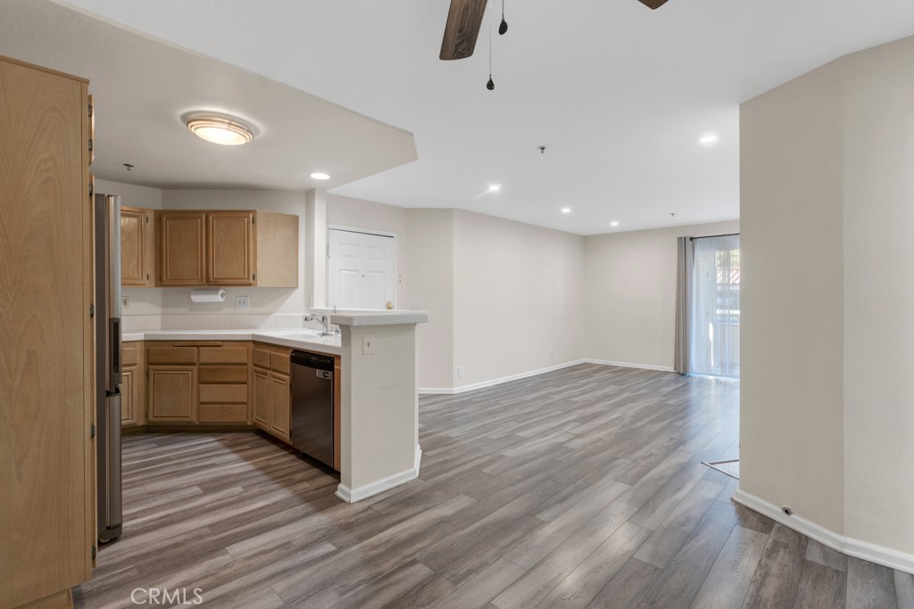 5744 Oak Bend Lane, Unit 203 Oak Park, CA 91377 - Photo 14 of 45 a kitchen with stainless steel appliances granite countertop a sink cabinets and wooden floor