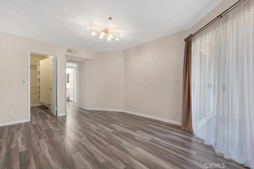 5744 Oak Bend Lane, Unit 203 Oak Park, CA 91377 - Photo 6 of 45 a view of an empty room with wooden floor and a window