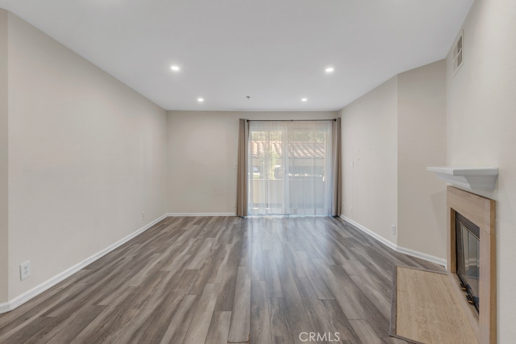 5744 Oak Bend Lane, Unit 203 Oak Park, CA 91377 - Photo 8 of 45 a view of an empty room with wooden floor and a window