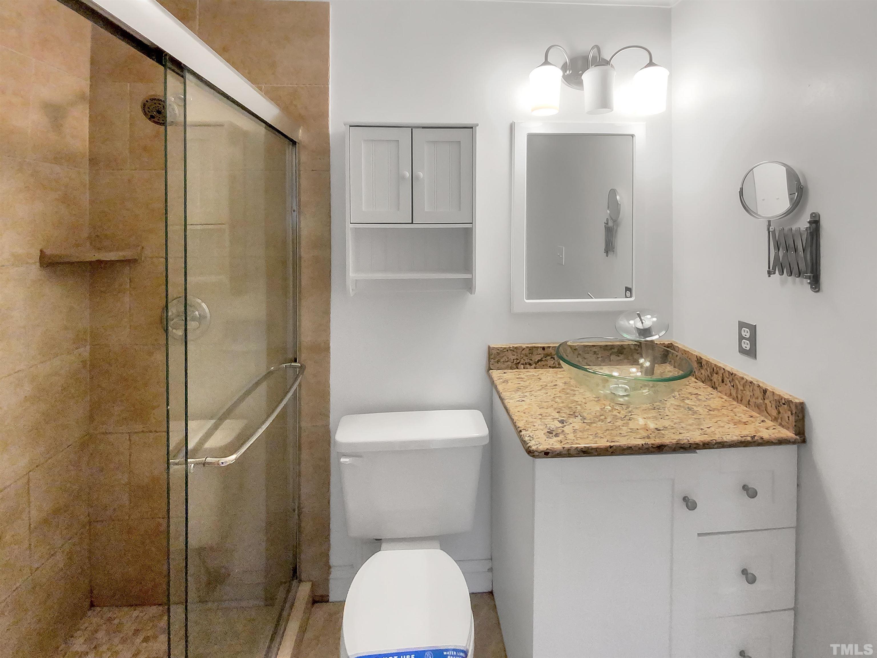 1007 Castalia Drive Cary, NC 27513 - Photo 4 of 17 a bathroom with a granite countertop sink a toilet and shower