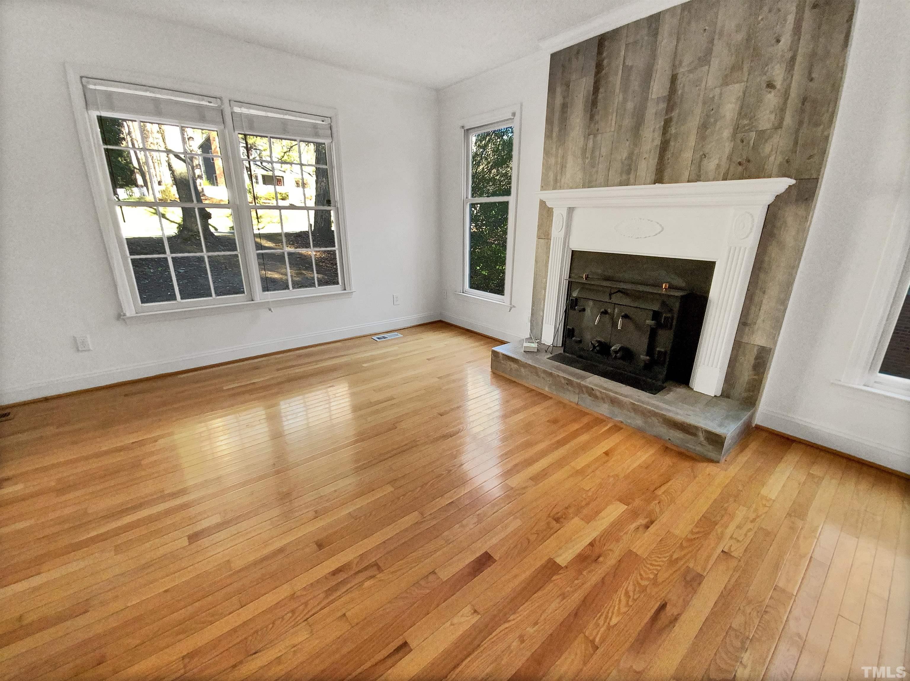 1007 Castalia Drive Cary, NC 27513 - Photo 7 of 17 a view of an empty room with wooden floor fireplace and a window