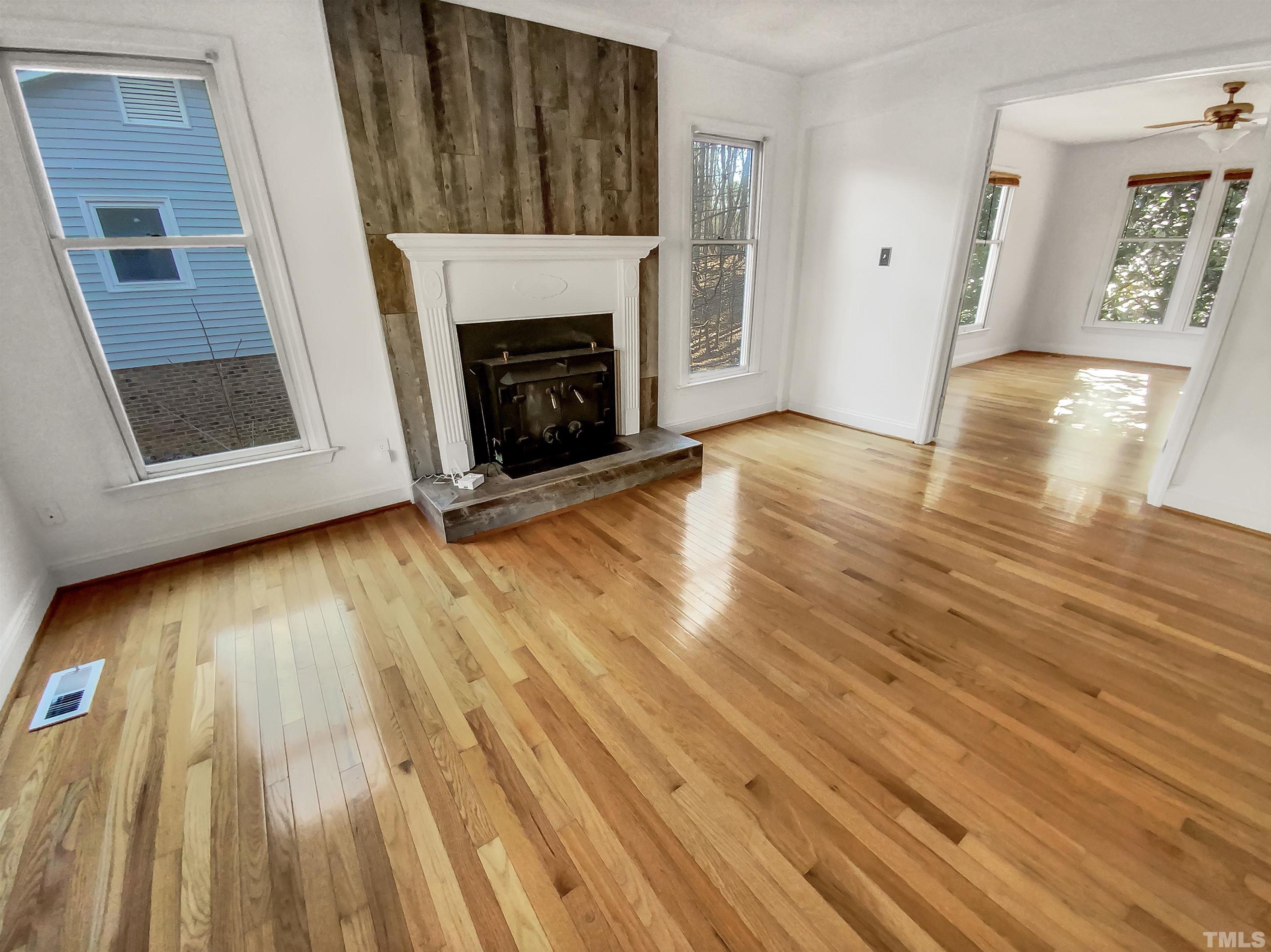 1007 Castalia Drive Cary, NC 27513 - Photo 8 of 17 a view of an empty room with wooden floor and a fireplace