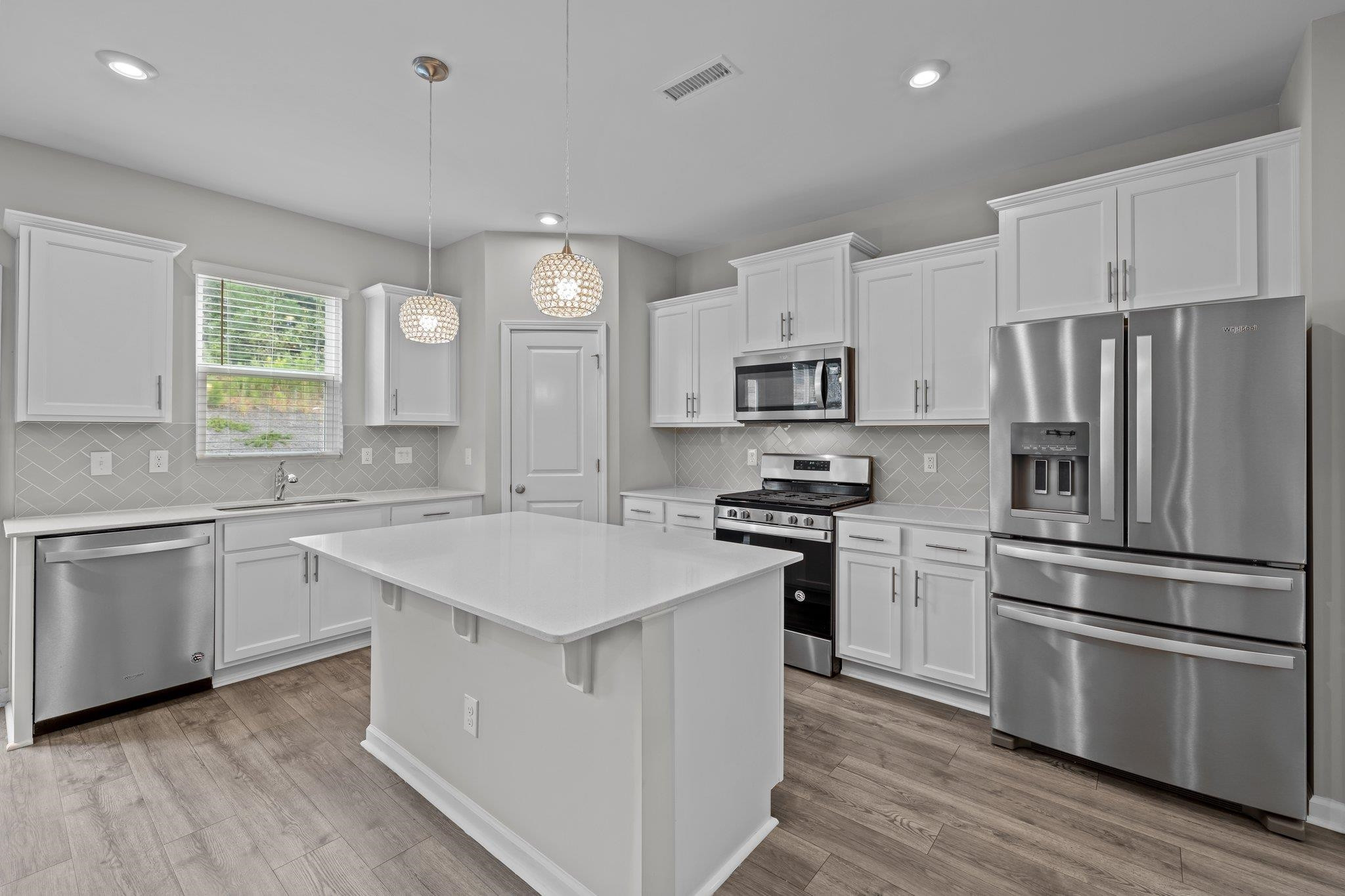 91 Stromness Path Clayton, NC 27527 - Photo 18 of 48 a kitchen with white cabinets and stainless steel appliances