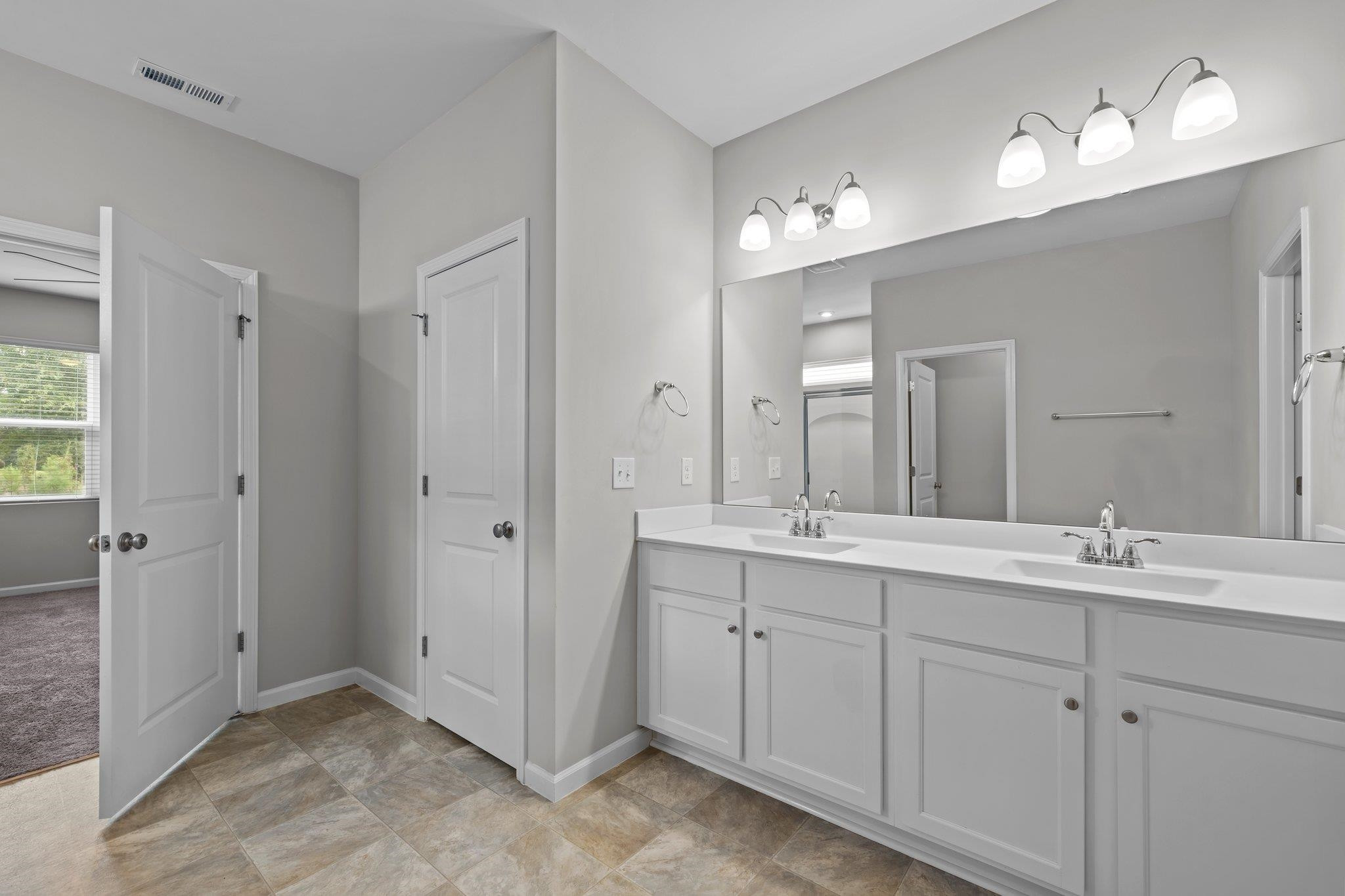 91 Stromness Path Clayton, NC 27527 - Photo 39 of 48 a bathroom with a double vanity sink mirror and next to a window