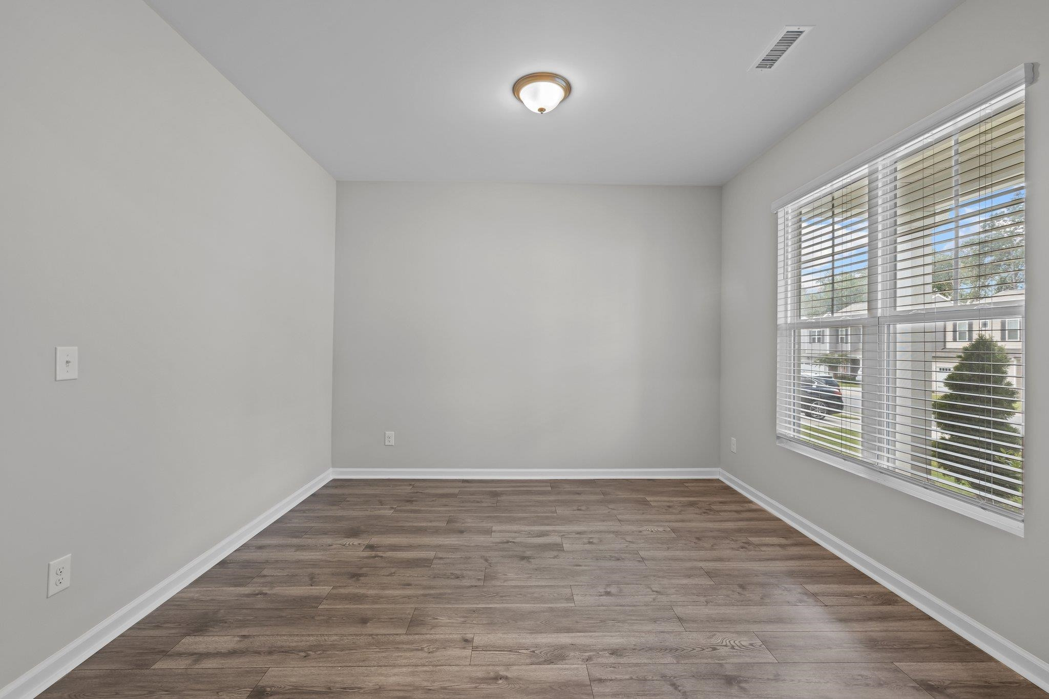 91 Stromness Path Clayton, NC 27527 - Photo 9 of 48 a view of an empty room with wooden floor and a window