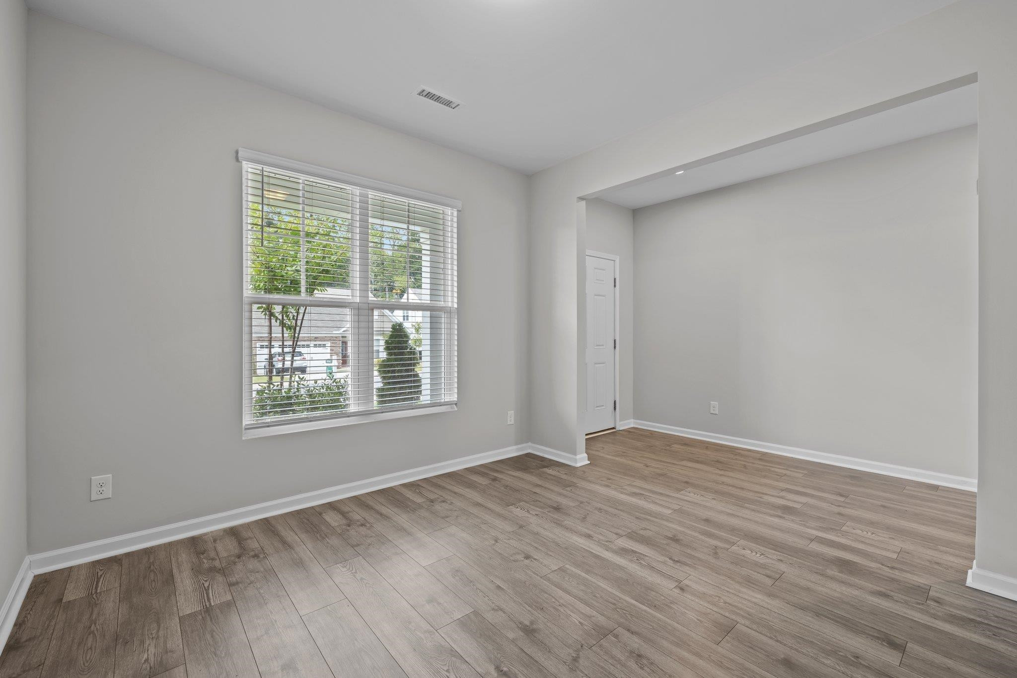 91 Stromness Path Clayton, NC 27527 - Photo 10 of 48 a view of an empty room with wooden floor and a window