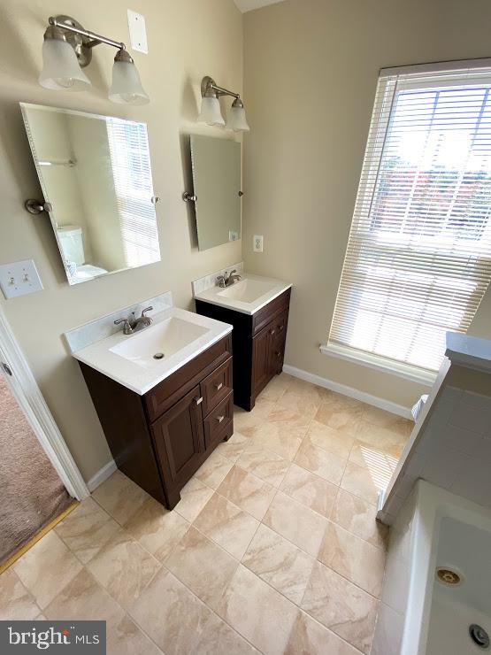 6004 Cedar Post Drive District Heights, MD 20747 - Photo 11 of 28 a bathroom with a double vanity sink window and mirror