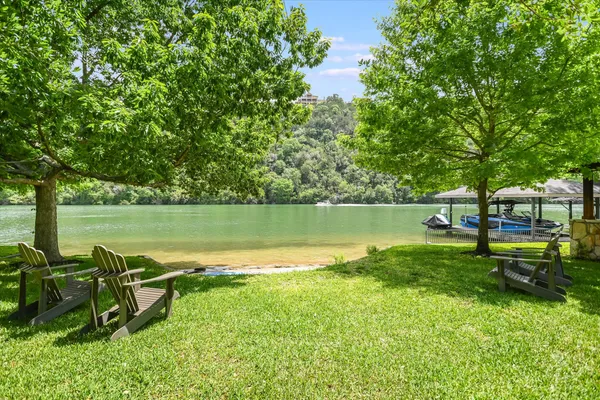 a view of a lake with a garden and a bench