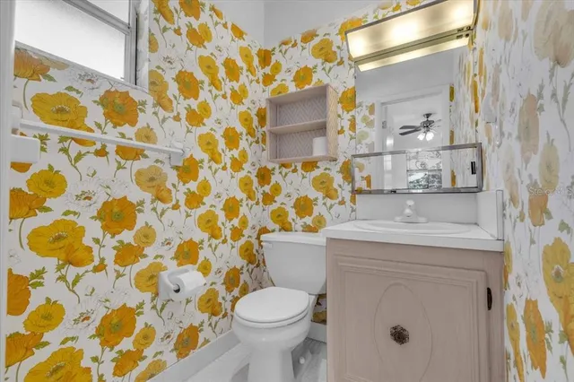 a bathroom with a granite countertop toilet and a sink